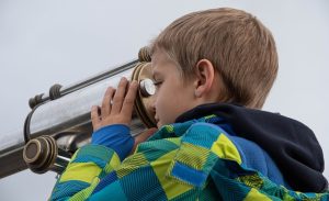 A Child Looking Through a Telescope